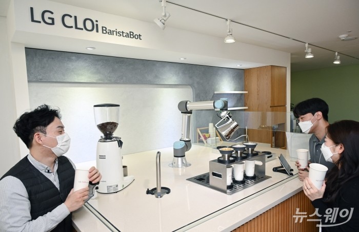 직원들이 바리스타봇이 커피를 만드는 장면을 보고 있다. 사진=LG전자 제공