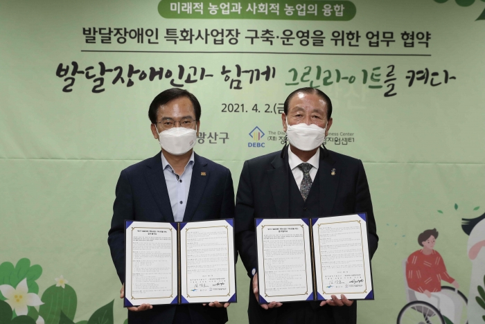 광주 광산구와 (재)장애인기업종합지원센터는 ‘발달장애인 특화사업장 구축·운영을 위한 업무협약’을 2일 맺었다. 김삼호 광산구청장(왼쪽)과 서기영 이사장이 각자 서명한 협약서를 들어보이고 있다.