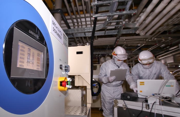 LG디스플레이 파주 공장에 설치된 온실가스 감축설비를 통해 배출되는 온실가스량을 직원들이 모니터링하고 있다. 사진=LG디스플레이 제공
