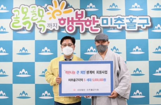 9일 김정식 미추홀구청장(왼쪽)이 석종연 미추홀공덕회 이사장으로부터 성금을 전달 받고 있다.