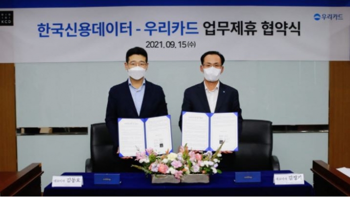 김정기 우리카드 대표이사(오른쪽)와 김동호 한국신용데이터 공동대표가 협약식을 마치고 기념촬영하고 있다. 사진=우리카드