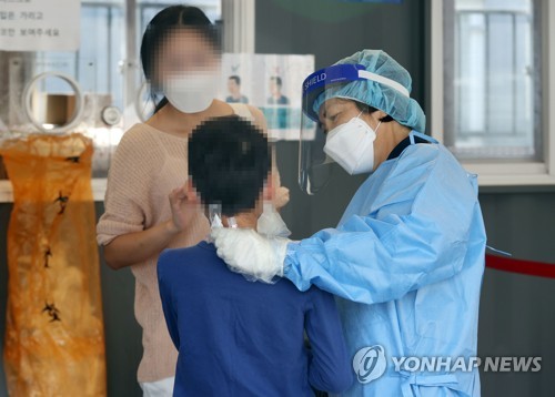 3일 서울역광장에 마련된 신종 코로나바이러스 감염증(코로나19) 임시 선별검사소에서 한 어린이가 검사를 받고 있다. 사진=연합뉴스 제공