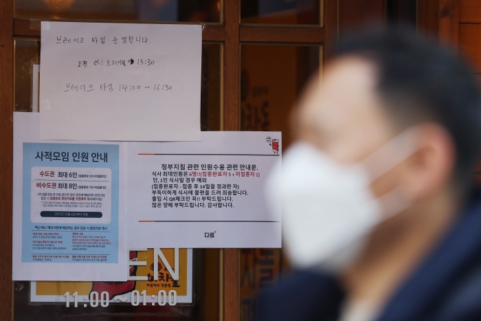 신종 코로나바이러스 감염증(코로나19) 확산으로 정부가 방역을 강화한 가운데 8일 오후 서울 홍대 거리의 한 식당에 사적모임 인원 안내문이 붙어 있다. 사진=연합뉴스 제공