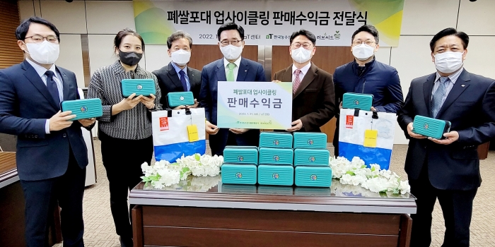 김춘진 한국농수산식품유통공사 사장(왼쪽 4번째)이 폐쌀포대를 재활용하여 제작한 업사이클링 파우치백의 판매수익금 전액을 국제구호단체 러브씨드 김훈 대표(오른쪽 3번째)에 기부했다