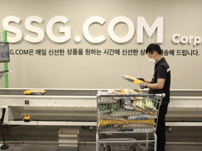 SSG닷컴은 오는 31일 자정부터 배송비 부과 기준을 변경한다. 사진은 이마트 이천점 PP센터에서 작업자가 자동화 소터에 상품을 투입하는 모습. 사진=SSG닷컴 제공