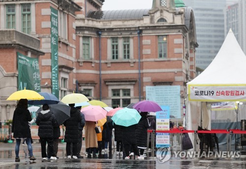 주말인 19일 비가 내리는 가운데 서울 중구 서울역 임시 선별검사소에서 우산을 쓴 시민들이 검사를 기다리고 있다. 사진=연합뉴스