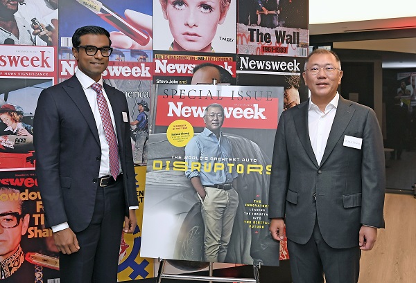 정의선 회장이 『뉴스위크』 특집호 표지 대형 포스터 앞에서 데브 프라가드(Dev Pragad, 사진 좌측) 『뉴스위크』 CEO와 기념촬영을 하고 있다. 사진=현대차그룹 제공