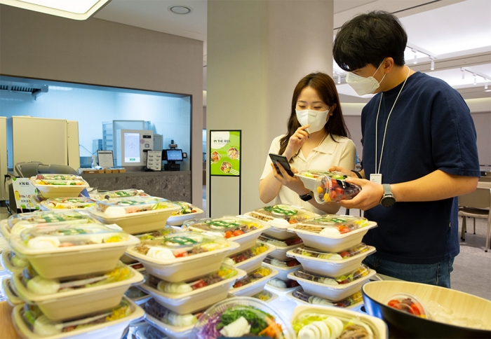 아워홈 구내식당 방문 고객들이 애플리케이션 '밀케어(Meal Care)'에 접속해 서비스를 이용하고 있다. 사진=아워홈 제공