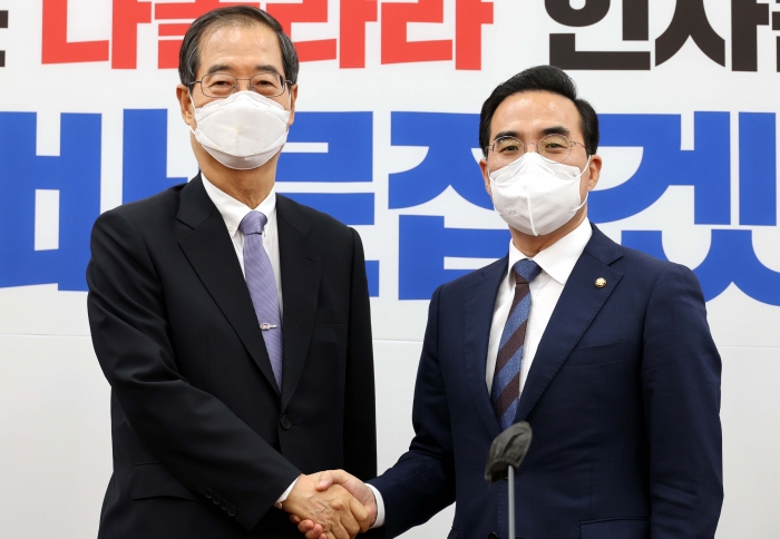 한덕수 국무총리(왼쪽)가 21일 국회에서 더불어민주당 박홍근 원내대표를 예방해 악수하고 있다. 사진=국회사진취재단