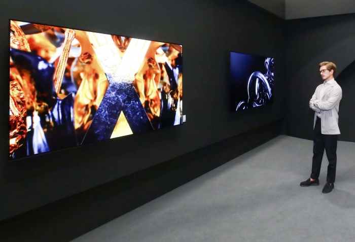 LG전자 모델이 '프리즈 서울'에서 LG 올레드 TV와 함께 전시된 작가의 예술 작품을 감상하고 있다. 사진=LG전자 제공