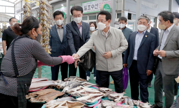 김영록 전라남도지사가 8일 신안지도시장을 방문해 상인들을 만나 애로사항을 수렴하고 지역 특산품을 구매하고 있다.