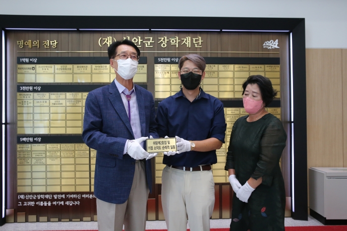 신안군 소악도 쉬랑께2호점 김현우 대표가 15일 신안군 학생들을 위해 써달라며 장학기금 1천만원을 (재)신안군장학재단에 기탁하고 있다.
