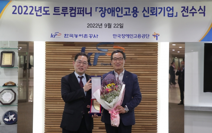농어촌공사 이병호 사장(오른쪽)이 한국장애인고용공단 차정훈 고용촉진이사로부터 트루컴퍼니 금상 상패를 받았다.
