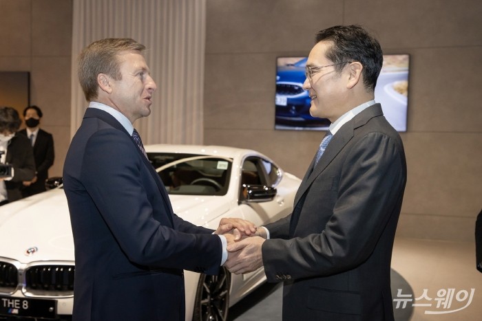 이재용 삼성전자 회장이 17일 인천 영종도에 위치한 BMW 드라이빙 센터를 찾아 올리버 집세 BMW CEO와 손을 맞잡고 대화를 다누고 있다. 사진=삼성전자 제공