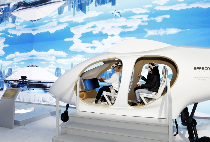 관람객들이 CES에 전시된 SK텔레콤의 도심항공교통(UAM) 모형에 탑승해 운행 체험을 하고 있다. 사진=SK 제공