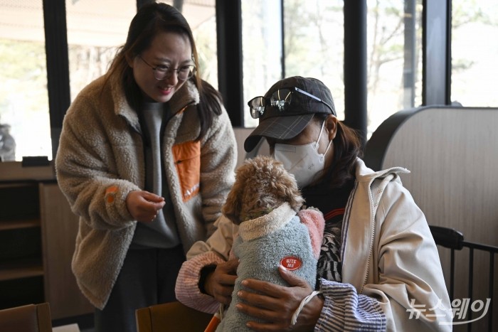 유기견 입양 상담자가 3일 오후 경기 남양주시 스타벅스 더북한강R점에서 진행된 보호소 동물들 봄소풍 가는 날 행사에서 유기견을 끌어 안고 있다. 사진=강민석 기자 kms@newsway.co.kr