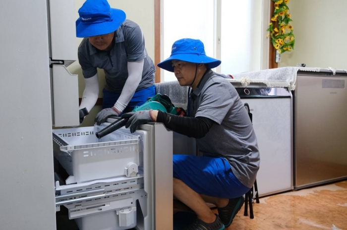 삼성전자서비스 임직원이 침수된 냉장고를 건조 및 세척하고 있다. 사진=삼성전자서비스 제공