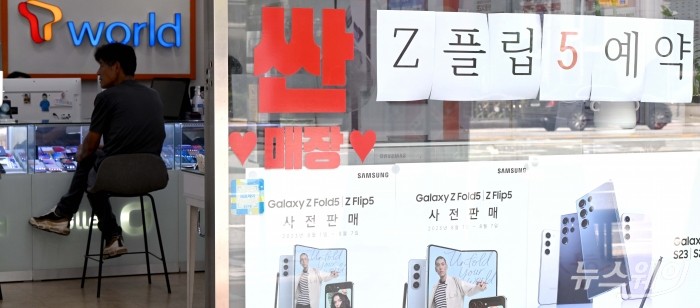 삼성전자의 신제품 갤럭시Z폴드5·플립5 사전예약을 소개하는 안내문이 28일 오후 서울 시내에 위치한 이동통신사 매장 유리벽에 부착된 가운데 소비자가 상담을 받고 있다. 사진=강민석 기자 kms@newsway.co.kr