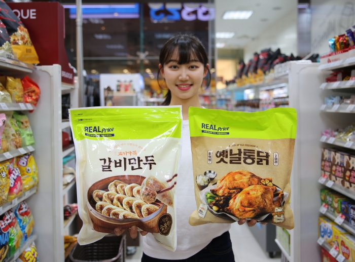 모델이 GS25가 물가안정 상품으로 도입한 GS프레시의 전용 브랜드 리얼프라이스 상품 2종(고기가득 갈비만두·추억의 옛날통닭)을 들고 포즈를 취하고 있다. 사진=GS리테일 제공