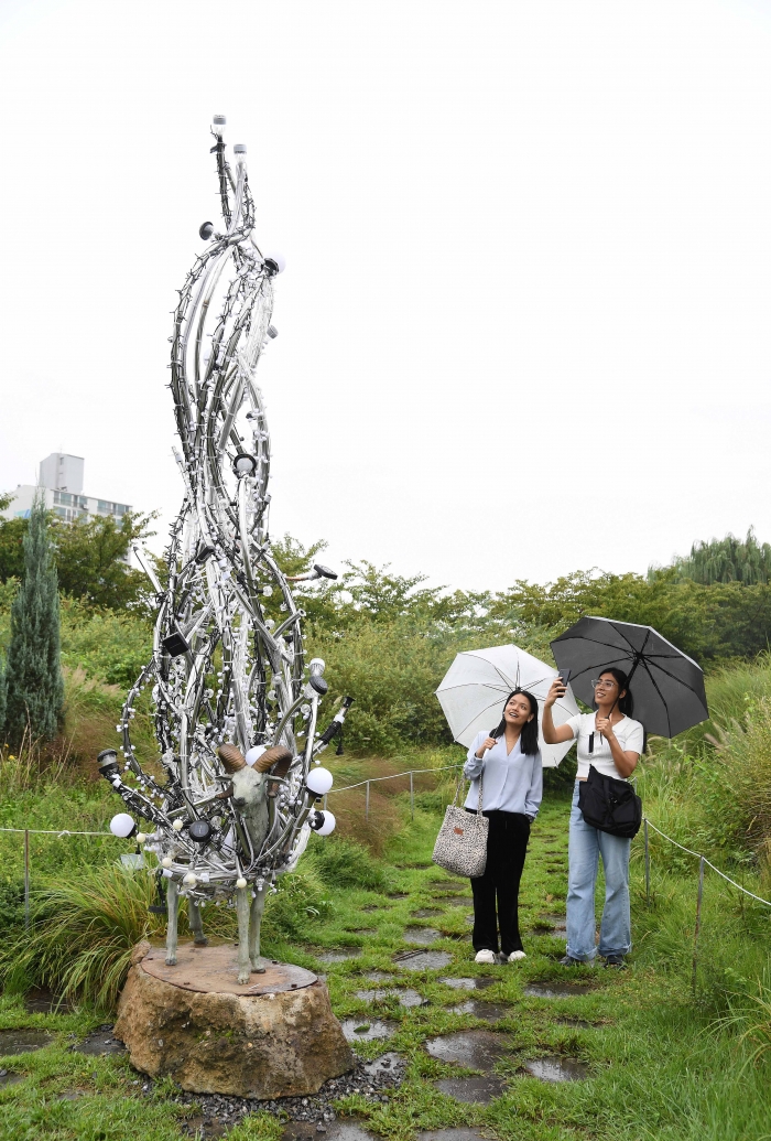 뚝섬한강공원에서 열린 2023 한강조각프로젝트에서 시민들이 '송필' 작가의 '실크로드' 작품을 감상하고 있다. 사진=크라운해태제과 제공
