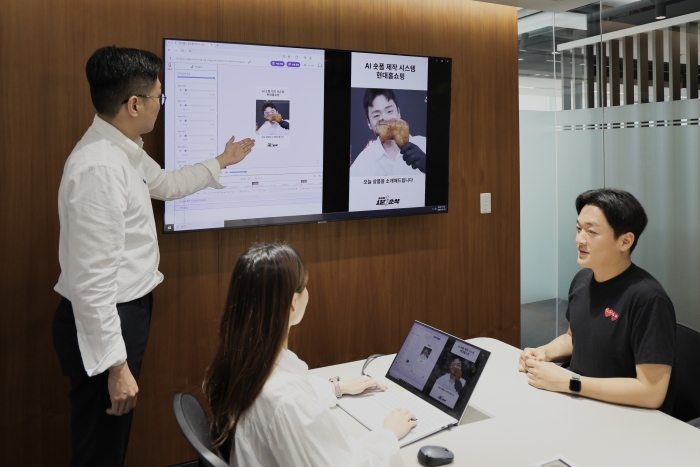 현대홈쇼핑 직원들이 AI 숏폼 자동 제작 시스템을 시연하고 있는 모습/사진=현대홈쇼핑 제공