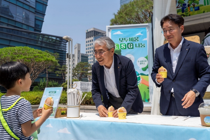 11일 농협금융 본사 광장에서 실시된 'NH-Ecycling Day' 폐전자제품 기부행사에서 고장난 전자제품을 들고 참여한 아이에게 이석준 농협금융지주 회장(왼쪽), 이석용 농협은행 은행장(오른쪽)이 도넛을 나눠주고 있다. 사진=NH농협금융 제공