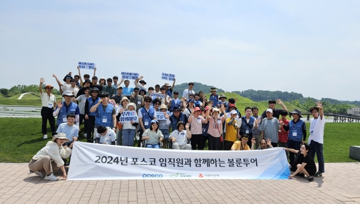 광양 지역 장애인들이 21일 포스코 임직원 및 봉사단과 함께 순천만국가정원을 방문한 뒤 기념촬영 하고 있다.