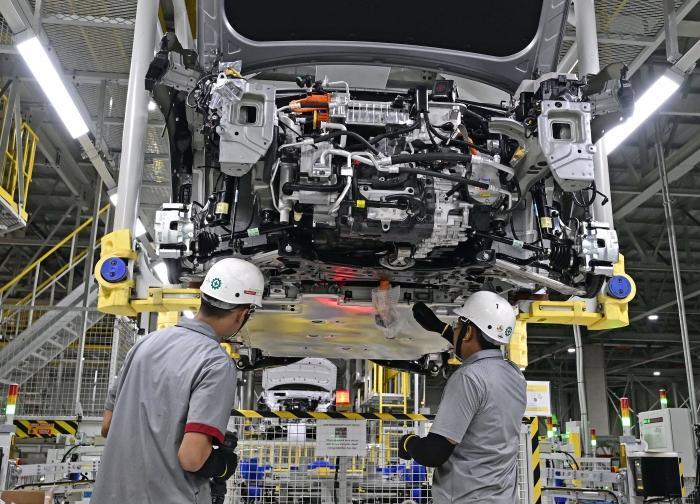 현대자동차 인도네시아공장 근로자들이 더 뉴 코나 일렉트릭에 HLI그린파워에서 생산한 배터리를 체결하고 있다. 사진=현대자동차 제공