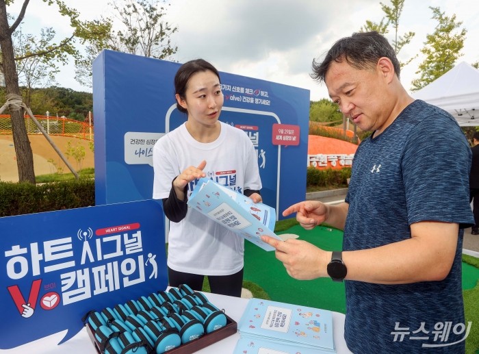 대한심혈관중재학회가 세계 심장의 날을 맞아 25일 서울 보라매공원 풍경놀이터 앞에서 '하트시그널V 캠페인, 건강한 내 심장을 위한 나이스 샷' 행사를 개최한 가운데 시민들에게 심장 판막 질환의 원인과 증상, 진단과 치료법 관련 정보를 소개하고 있다. <br />
사진=대한심혈관중재학회