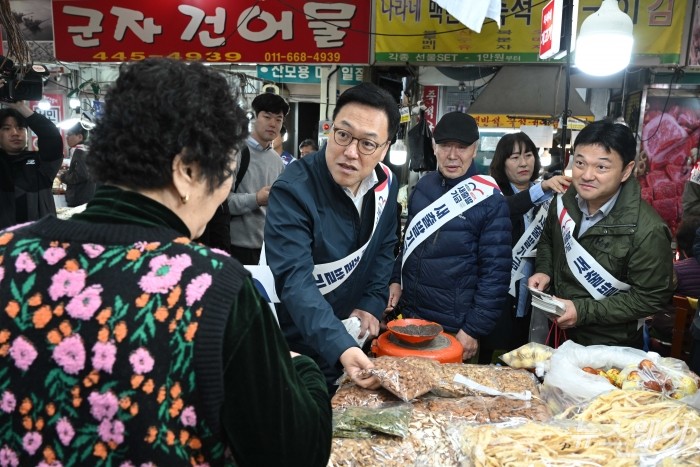 김병환 금융위원회 위원장이 22일 오전 경기 안양시 안양중앙시장에서 '새출발기금'을 홍보하며 견과류를 구매하고 있다. 사진=강민석 기자 kms@newsway.co.kr