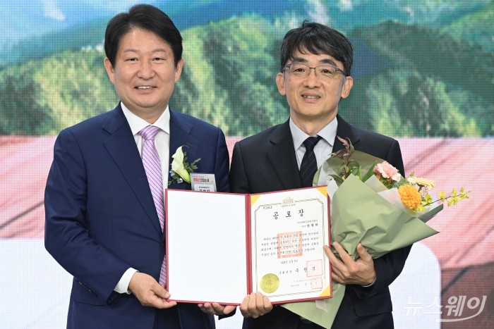 권영진 국회 국토교통위원회 간사가 8일 오전 서울 서초구 감정평가사회관에서 열린 '부동산 산업의 날' 기념식에서 안창덕 대화감정평가법인 이사에게 국회의장 공로장을 수여한 뒤 기념촬영을 하고 있다. 사진=강민석 기자 kms@newsway.co.kr