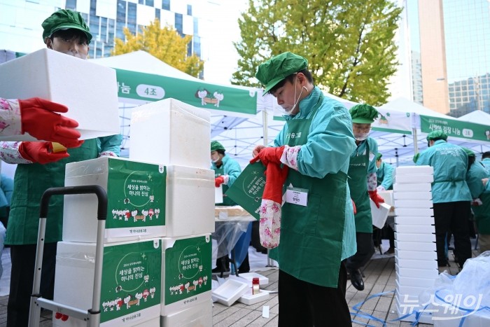 하나금융그룹의 임원이 11일 오전 서울 중구 하나금융그룹명동사옥 정문에서 열린 2024년 모두하나데이 '사랑의 김장나눔'에서 김장을 보관한 박스에 부착할 스티커를 작업하고 있다. 사진=강민석 기자 kms@newsway.co.kr