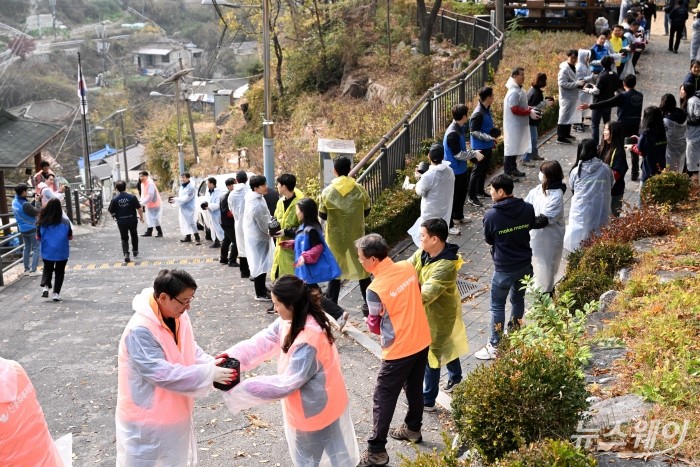 금융권 합동 '사랑의 온기 나눔' 활동이 21일 오후 서울 서대문구 개미마을에서 열린 가운데 참석자들이 연탄을 전달하고 있다. 사진=강민석 기자 kms@newsway.co.kr