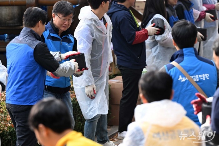 (왼쪽 두 번째)이재연 신용회복위원회 위원장 겸 서민금융진흥원장이 21일 오후 서울 서대문구 개미마을에서 열린 금융권 합동 '사랑의 온기 나눔' 활동에서 김병칠 금융감독원 부원장보에게 연탄을 전달하고 있다. 사진=강민석 기자 kms@newsway.co.kr