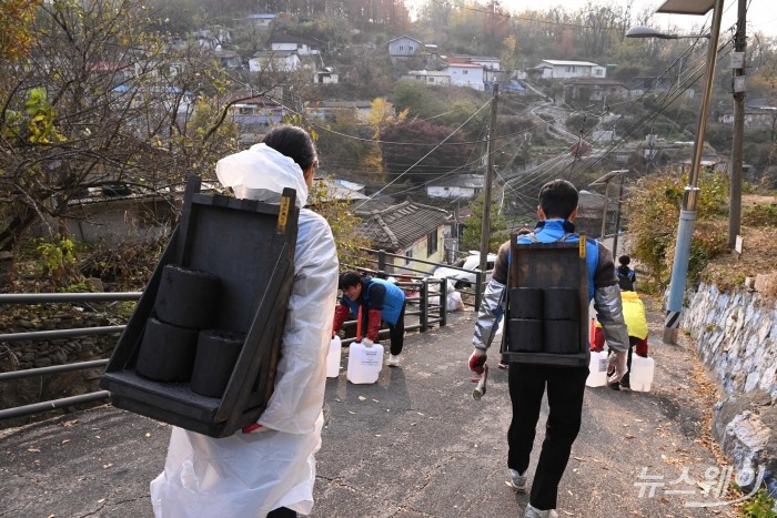 금융권 합동 '사랑의 온기 나눔' 활동이 21일 오후 서울 서대문구 개미마을에서 열린 가운데 참석자들이 연탄과 난방유를 독거노인 및 영세가정에 나르고 있다. 사진=강민석 기자 kms@newsway.co.kr