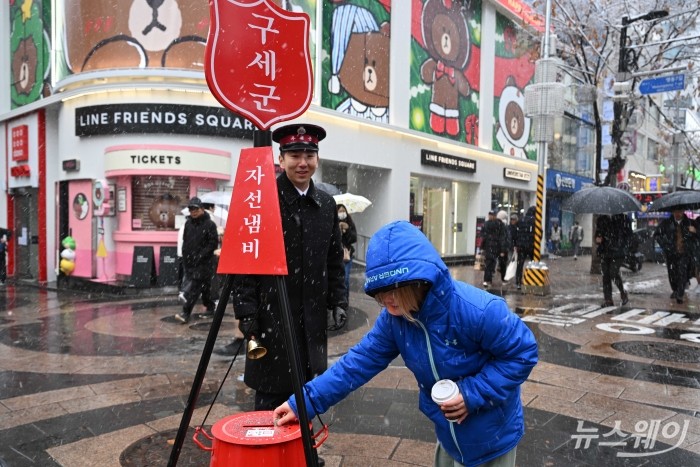 외국인 기부자가 27일 오후 서울 중구 명동거리 인근에 마련된 한국구세군의 자선냄비모금함에 성금을 하고 있다. 사진=강민석 기자 kms@newsway.co.kr