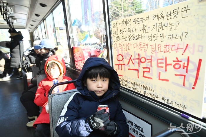 '윤석열 대통령 탄핵버스'가 14일 오후 서울 국회의사당 인근에서 열린 '내란수괴 윤석열 즉각 탄핵 범국민촛불 大행진' 집회에 마련된 가운데 시민들과 어린이들이 탑승하고 있다. 사진=강민석 기자 kms@newsway.co.kr