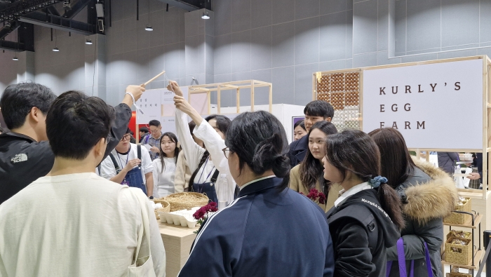 컬리에그팜에서 방문객이 직원의 도움을 받아 게임에 참여하고 있다. 컬리에그팜에서는 청란, 구엄닭 달걀과 같은 희소상품 만날 수 있다. 사진=조효정 기자