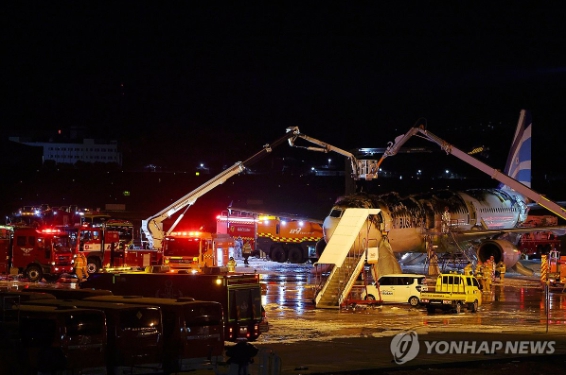 28일 오후 김해공항 계류장에서 승객 170명과 승무원 6명을 태우고 이륙을 준비하던 홍콩행 에어부산 항공기 BX391편 꼬리 쪽 내부에서 불이 나 소방대원들이 진화 작업을 하고 있다. 승객 170명과 승무원 6명이 슬라이드를 이용해 모두 비상 탈출해 큰 인명피해는 발생하지 않았다. 사진=연합뉴스