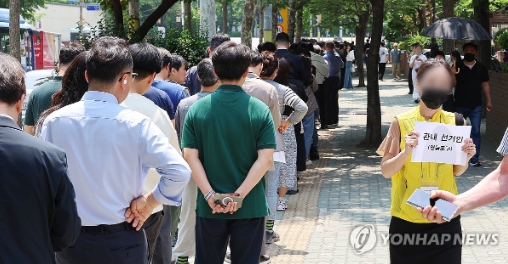 제21대 대통령 선거 사전투표 첫날인 29일 사전투표소가 설치된 서울 영등포구 여의동 주민센터 앞에 직장인들이 점심시간을 이용해 투표하기 위해 길게 줄지어 서 있다. 사진=연합뉴스