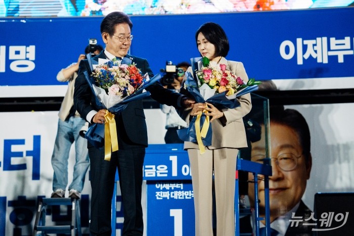 이재명 제 21대 대통령 당선인이4일 오전 국회 앞에 설치된 축하 무대에서 꽃다발을 선물 받은 후 부인 김혜경 여사의 손을 잡고 있다. 사진=이수길 기자 Leo2004@newsway.co.kr