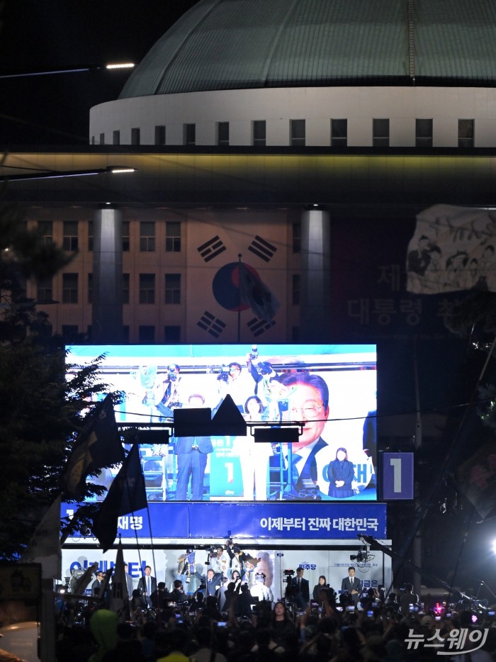 제21대 대통령 선거 이튿날인 4일 이재명 더불어민주당 대선 후보가 당선이 확실시되자 서울 여의도 국회 앞에 마련된 더불어민주당의 국민개표방송시청 현장을 찾아 당선 수락연설에 앞서 아내 김혜경 여사와 시민들을 향해 인사하고 있다. 사진=이수길 기자 Leo2004@newsway.co.kr