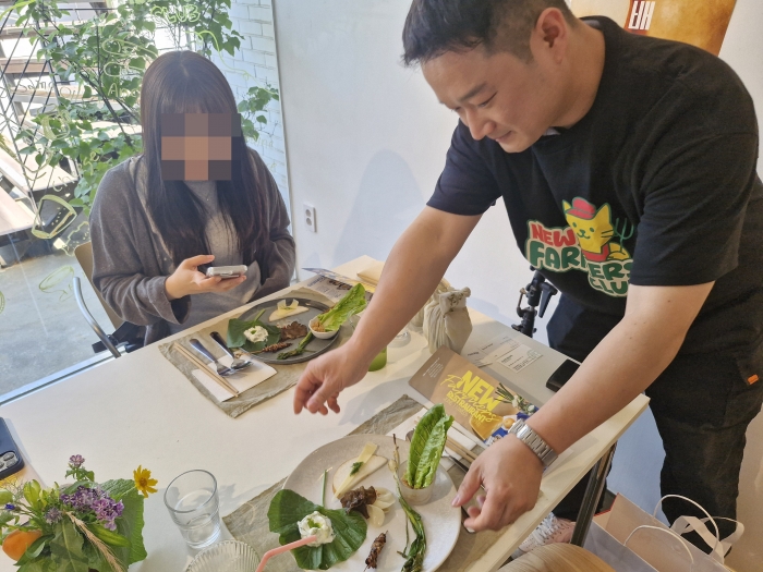 청년농부 정찬수 씨가 팝업 레스토랑 현장에서 손님에게 로메인 새비체 플레이팅을 선보이고 있다. 정씨는 스마트팜 시스템을 활용해 로메인 상추를 재배 중이다./사진=조효정기자