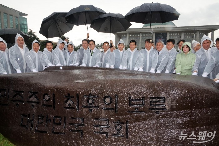 77주년 제헌절 기념 국회 상징석 제막식이 우원식 국회의장과 관계자들이 참석한 가운데 17일 여의도 국회잔디광장에서 열렸다. 참석자들이 상징석을 살펴보며 기념촬영 하고 있다. 사진=국회사진기자단 사진=이수길 기자 Leo2004@newsway.co.kr