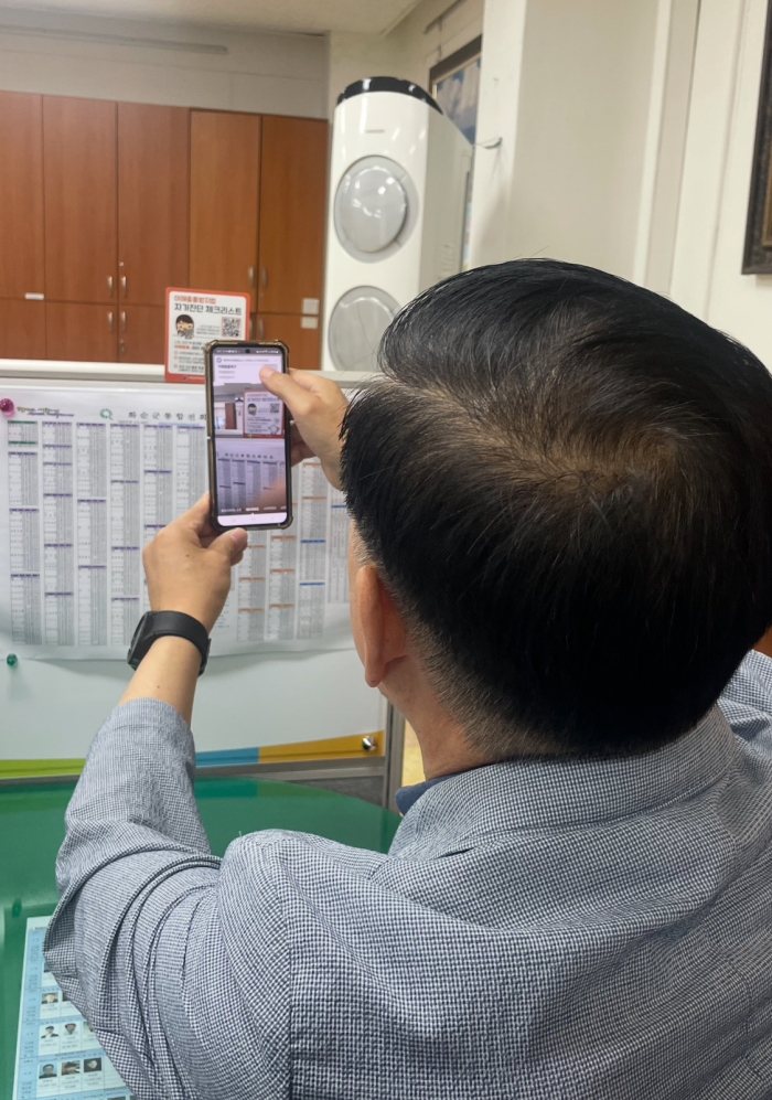 화순군 공직자가 이해충돌 방지법 스티커 QR코드를 연동하여 자가진단 체크하는 장면.
