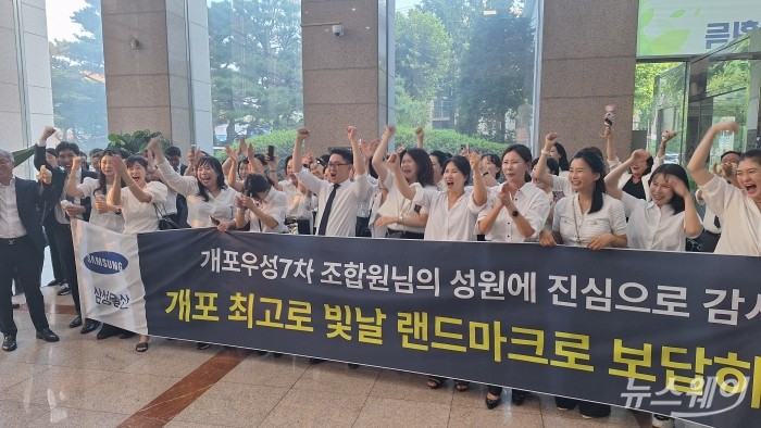 개포우성7차 재건축 사업 시공사로 삼성물산 관계자들이 현수막을 들고 축하하는 모습. 사진=김성배 기자