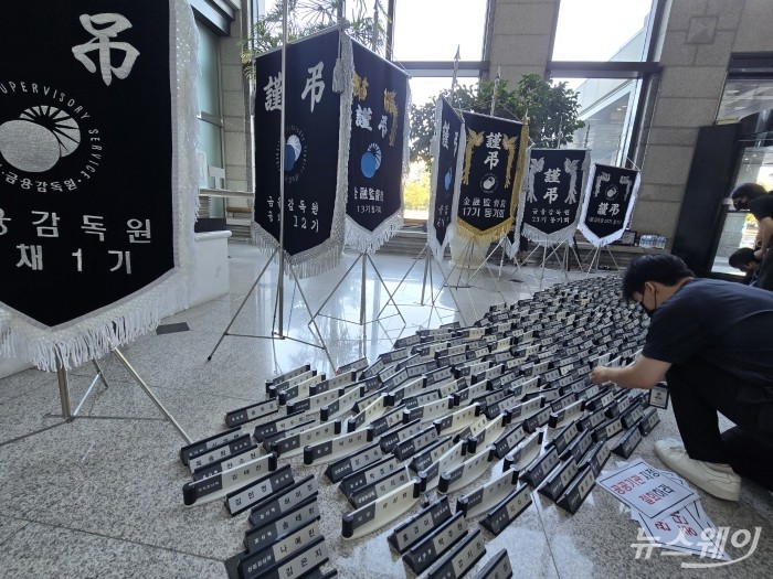 금융감독원 직원들이 11일 오전 금감원 서울 본원 1층 로비에서 명패를 내려놓는 퍼포먼스를 하고 있다. 사진=박경보 기자