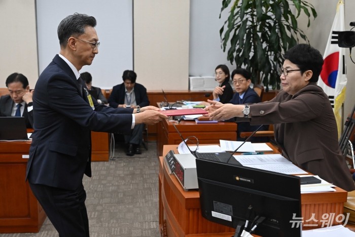 고정욱 롯데지주 사장이 13일 오후 서울 여의도 국회 기획재정위원회에서 열린 기획재정부(경제·재정정책)에 대한 2025년도 국정감사에 증인으로 출석해 증인선서문을 임이자 기재위 위원장에게 전달하고 있다. 사진=강민석 기자 kms@newsway.co.kr