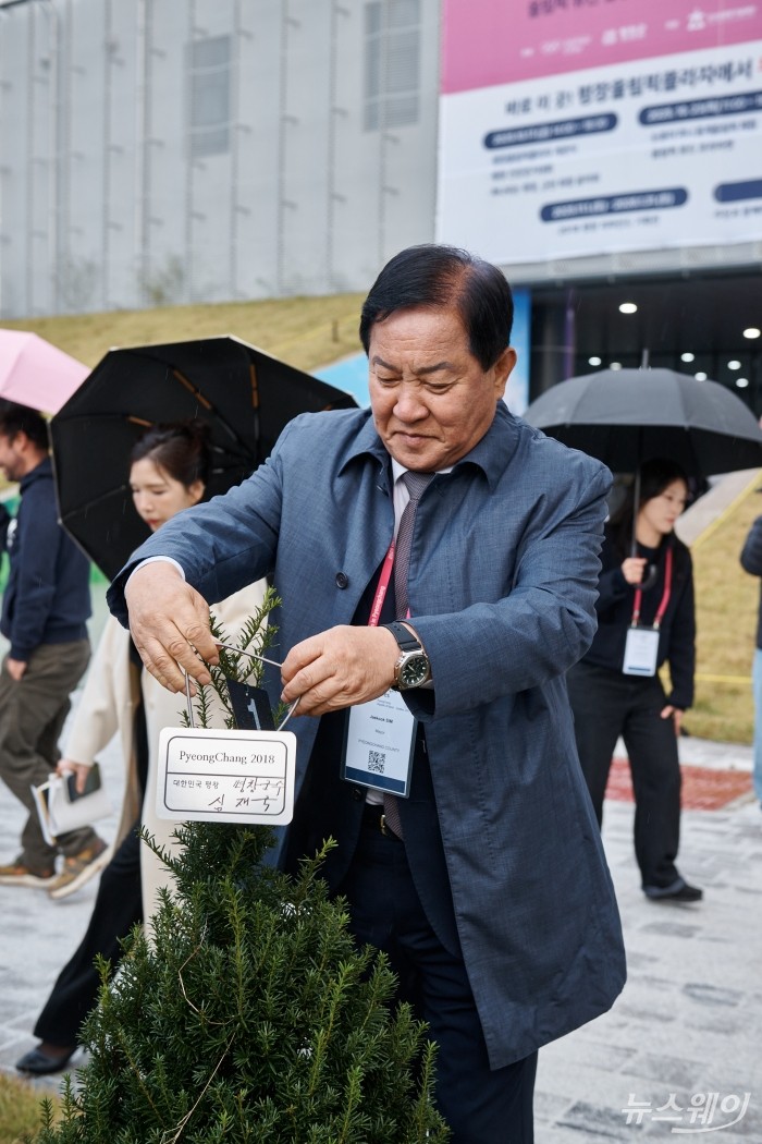 심재국 평창군수가 지난 23일 강원 평창군 대관령 평창올림픽플라자 일원에서 진행된 '2025 세계올림픽도시연맹 총회(World Union of Olympic Cities General Assembly)' 올림픽 레거시 포럼에서 기념 소나무에 명패를 달고 있다. 사진=2018평창기념재단