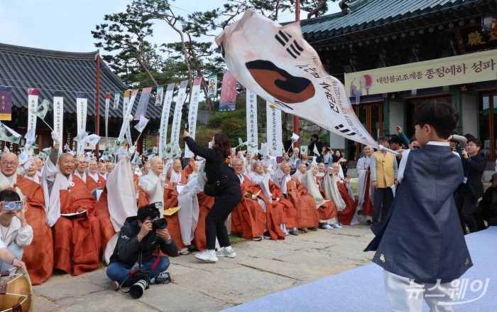 광복 80주년을 맞아 25일 서울 은평구 진관사에서 열린 국행수륙재 개건 627주년 기념 '2025년 진관사 수륙재' 회향식에서 어린이가 진관사 태극기를 흔들자 스님들이